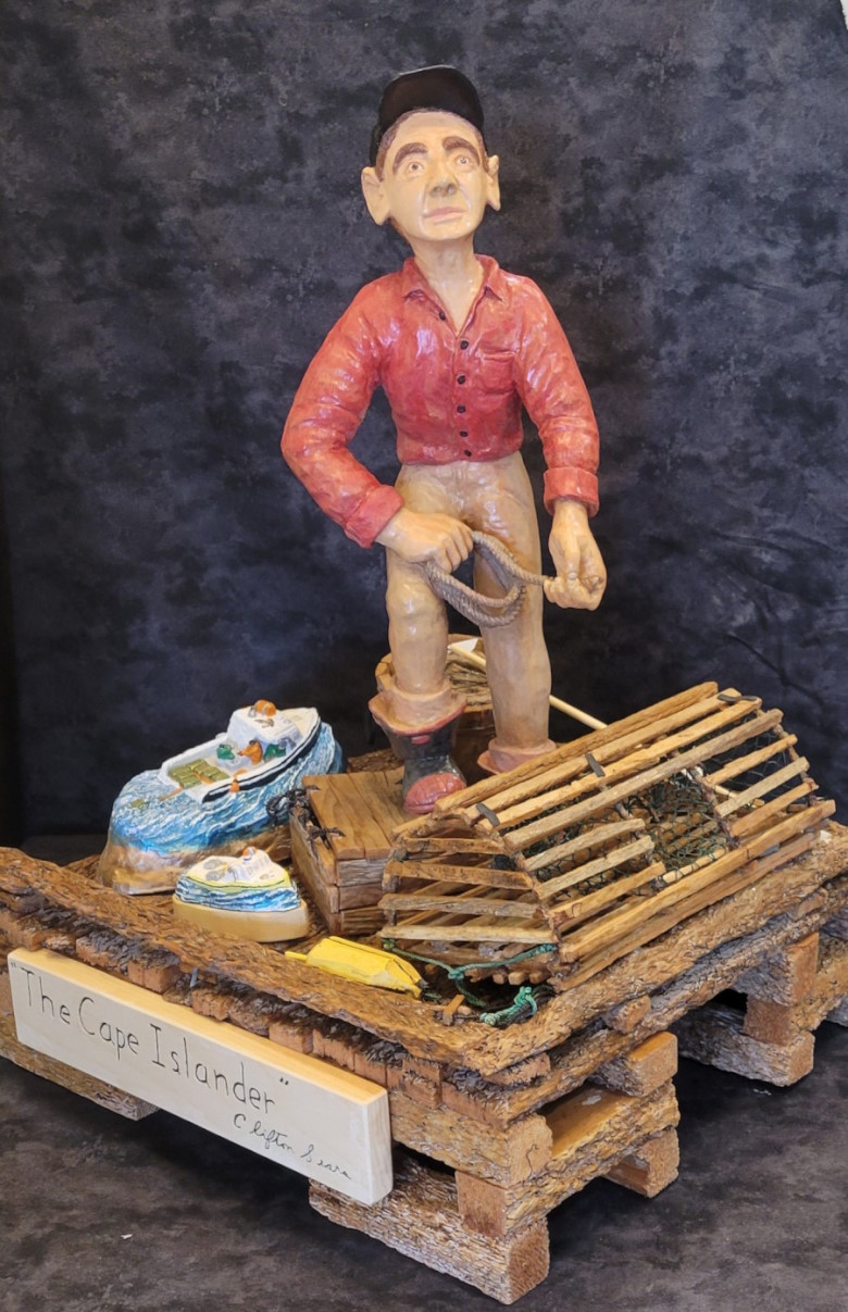 A fisherman standing on a wharf with fishing gear ans Cape Island style boats.