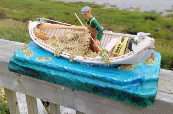 A fisherman is harvesting seaweed in his skiff.