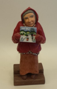 A wood carved portrait figurine of Nova Scotia folk artist Maud Lewis.